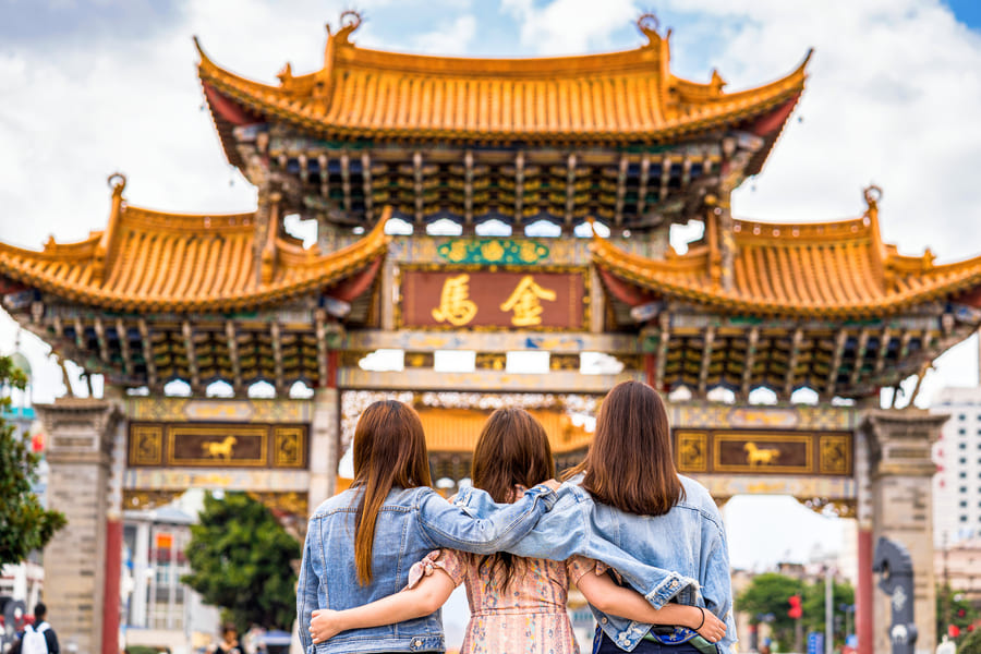 Familia de espaldas viendo un edificio con arquitectura tradicional China.